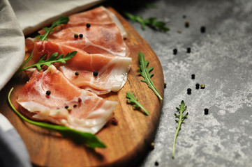 Prosciutto ham on wooden cutting board