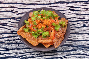 Spicy sour wing bean salad  with crispy pork served .