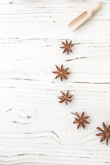 rice in wooden plate and anise on white wooden background. Rice and spices in ecological container. Set for cooking. Set for spa.