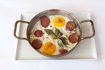 Fried eggs with sausage in pan