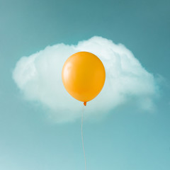 Yellow balloon with white cloud on blue sky in shape of an egg. Food concept. © Zamurovic Brothers