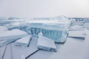 Turquoise ice floe. Ice-drift of Baikal lake. Winter landscape.