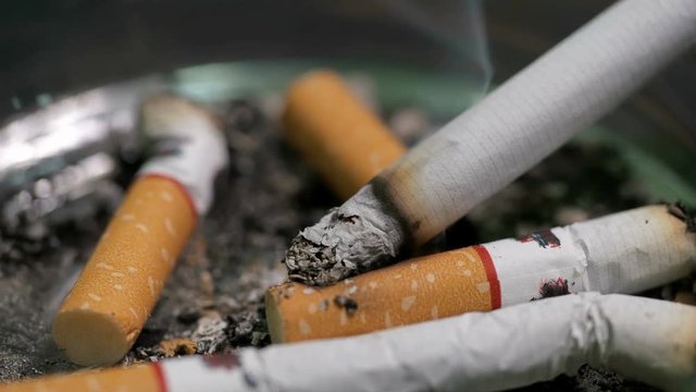 man puts a cigarette in an ashtray