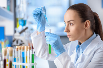 side view of concentrated scientist working with laboratory tube