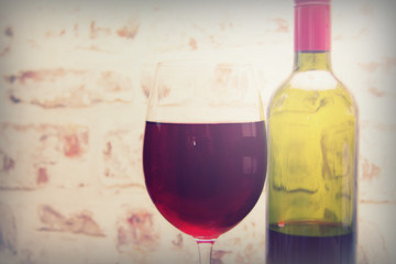 Bottle of red wine with glass ready to pour