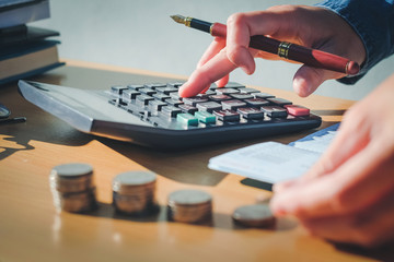 calculator and Financial data analyzing hand writing and counting in office on wood desk