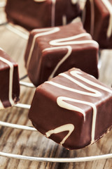 Small chocolate cakes (mignon) with cream on rustic wooden background