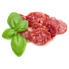 Salami smoked sausage slices and basil leaves isolated on white background cutout