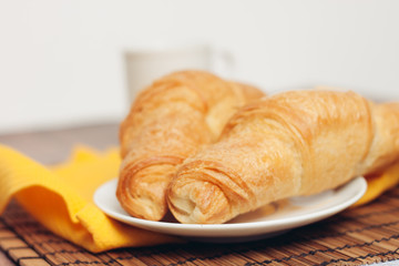 croissants on a plate, yellow napkin