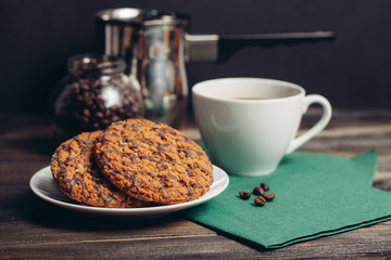 oatmeal cookies on a saucer, mug on a green napkin