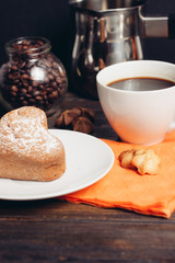 cupcake with sugar powder on a plate, a cup with a drink