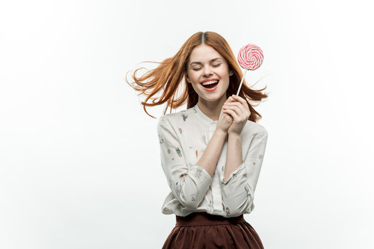 happy woman with red lollipop, light background