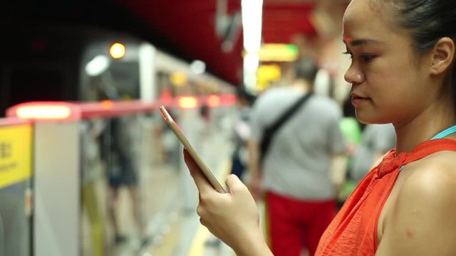 Asian woman hand using the tablet computer on the train, Metro of Taipei station in Taiwan-Dan