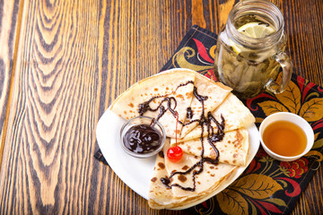 Pancakes with chocolate sauce and tea with honey