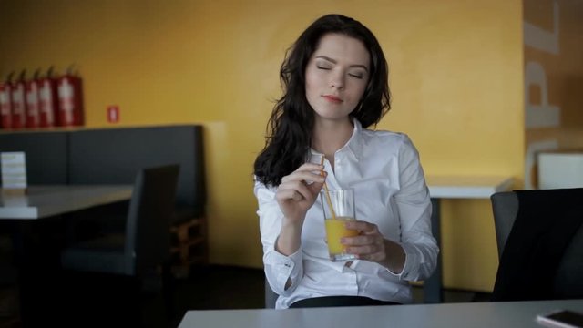 Young woman drinking fresh juice in cafe