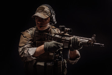 Fototapeta premium Portrait soldier or private military contractor holding sniper rifle. war, army, weapon, technology and people concept. Image on a black background.