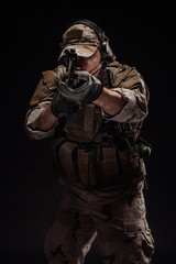 Portrait soldier or private military contractor holding sniper rifle. war, army, weapon, technology and people concept. Image on a black background.