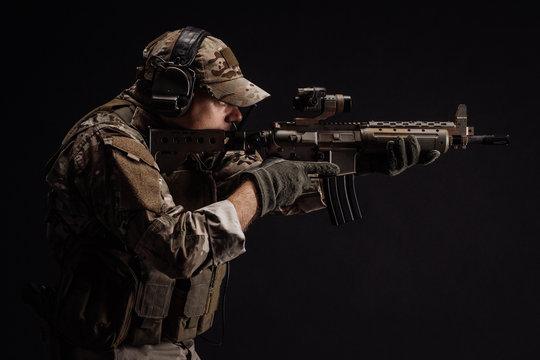 Portrait soldier or private military contractor holding sniper rifle. war, army, weapon, technology and people concept. Image on a black background.