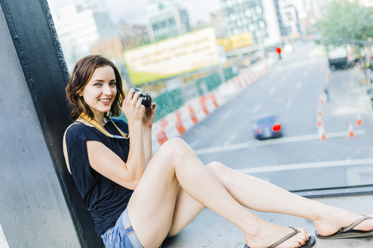 USA, New York City, smiling woman with camera on the High Line in Manhattan