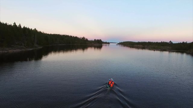 Unrecognizable people in boat at evening aerial shot