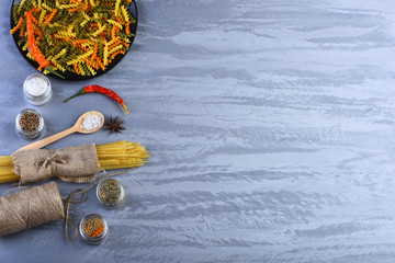 Bunch of spaghetti in sackcloth and fusilli in bowl