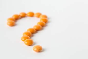 Orange pills in shape of question mark