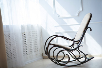 rocking chair near a sunny window light