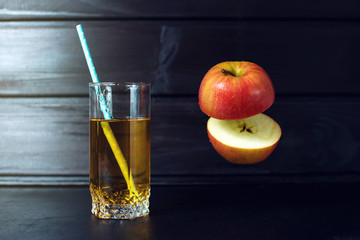 Glass of apple juice with sliced apple hanging in air