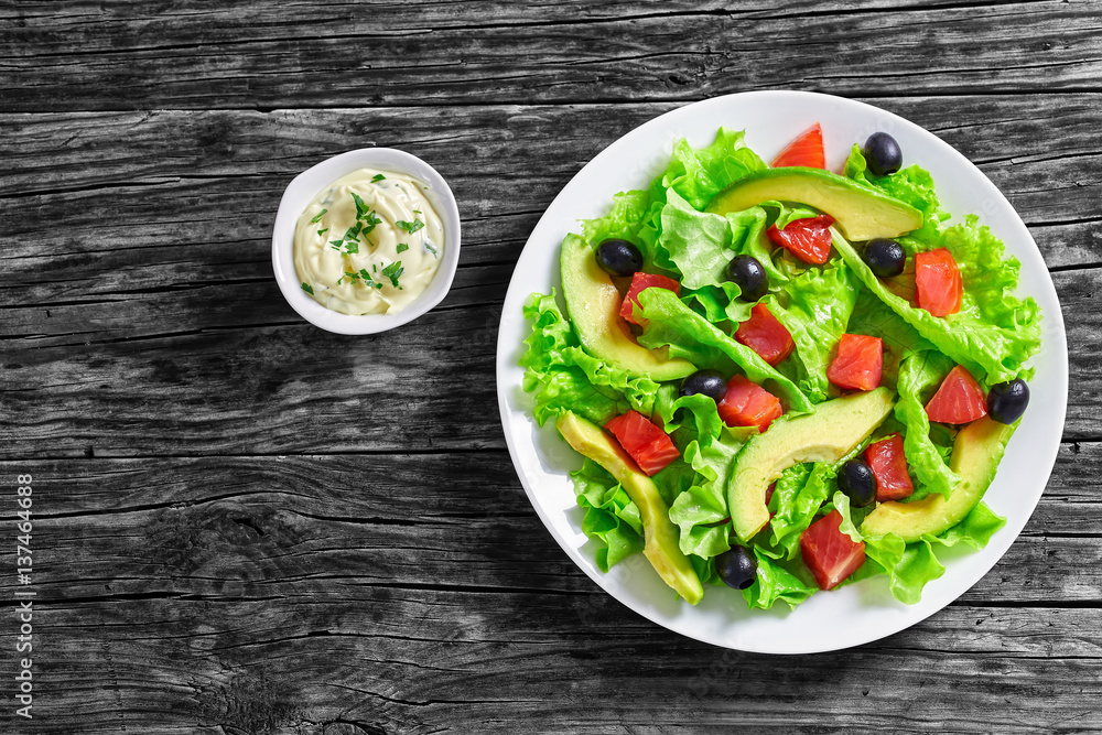 Poster salad of lettuce, avocado, chunks of salted salmon