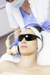 Naklejka premium Laser treatment at salon, woman with protective glasses