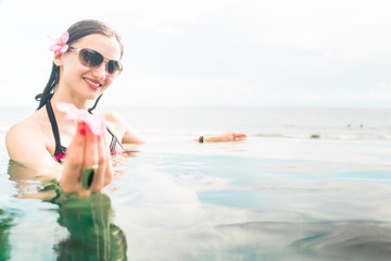 Female Tourist in infinity pool of hotel resort