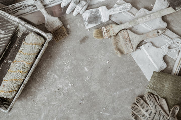 Plastering tools on cement background. View from top.