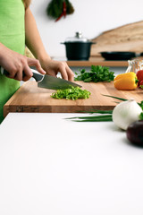 Close up of  woman's hands cooking in the kitchen. Housewife slicing ​​fresh salad. Vegetarian and healthily cooking concept