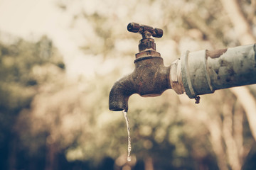 A faucet with a water drop / Water consumption and shortage concept