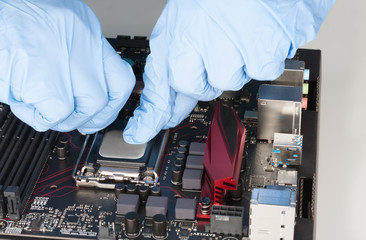 Fototapeta na wymiar Close up of man hands with gloves openning slot for CPU on motherboard
