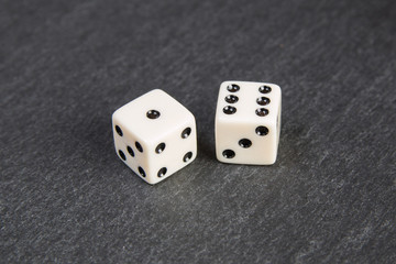 small dice on dark stone background	