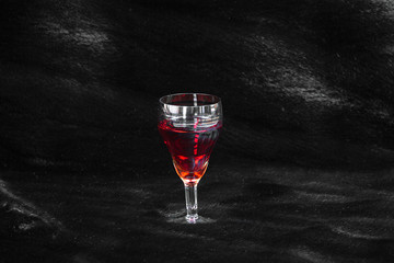 a glass of wine on a black background, black fur