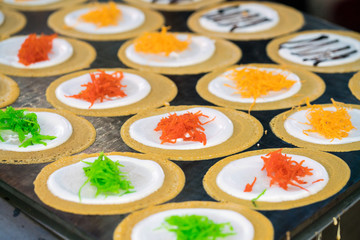 Close up Shot of thai crispy pancake - cream crepes cooking on the iron pan
Colorful of dessert.