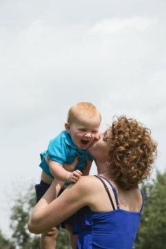 A mother kisses and plays with her young son; Stony Plain, Alberta, Canada