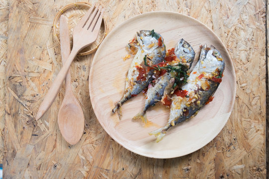 Mackerel fish fried topped spicy curry on wood dish