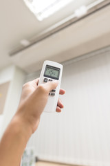 Hand hold air condition's remote and temperature setting is 25 degree celcius, Concept : Save Energy, Save World, Save money, Selective focus.