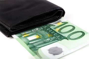 Banknotes of hundred euros sticking out of black wallet closed, on white background.