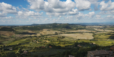 Landscape of rolling hills under a blue sky with cloud; Montepulciano, Umbria, Italy