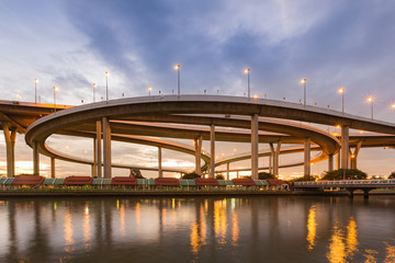 Round highway interchange at twilight with sunset sky background