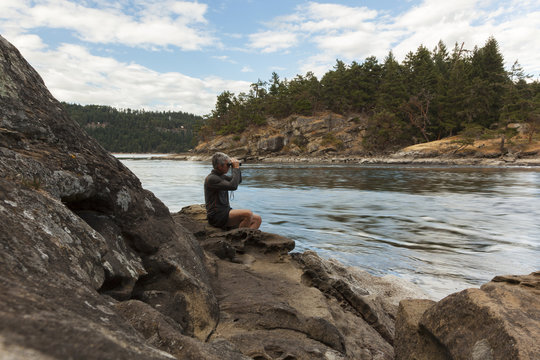 A senior man watches the tides at Dodds Narrows on Vancouver Island; British Columbia, Canada