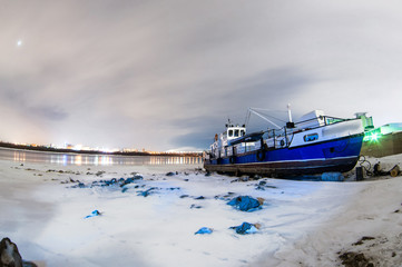 ships berth boat on shore in the winter night