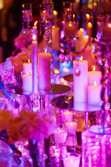 Table set with candles for a festive event, party or wedding reception, in purple light