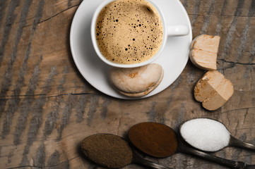 Coffee with foam and brown marshmallow on a wooden table