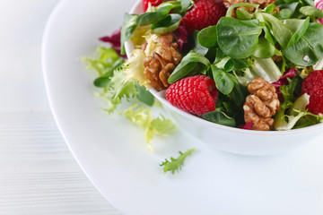 Green vegan salad with raspberry and nuts
