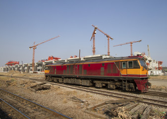 Fototapeta na wymiar Old diesel engine on railways track with construction in background